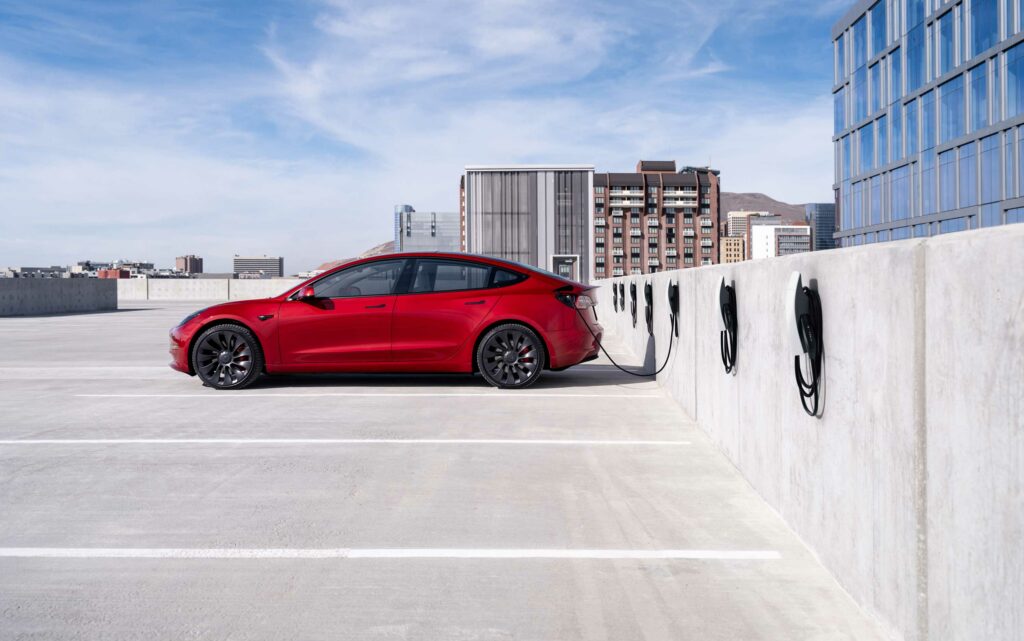 Punane Tesla Model 3 laadimas parkimismajas