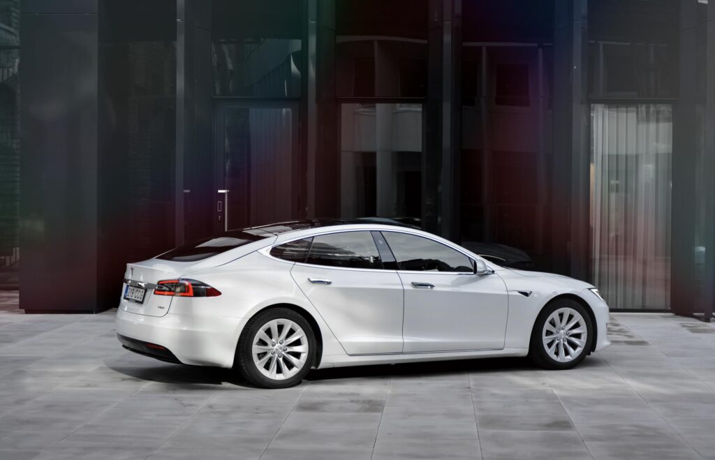 Tesla uksekäepide: valge Model S külgvaates linnas
