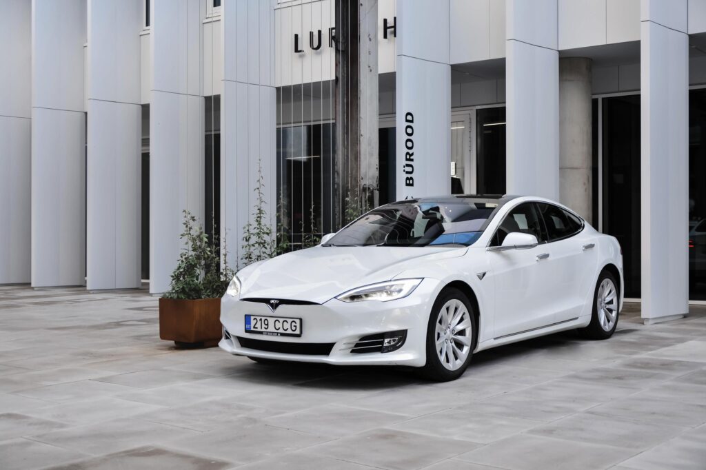 Valge Tesla Model S pargitud linnatänavale