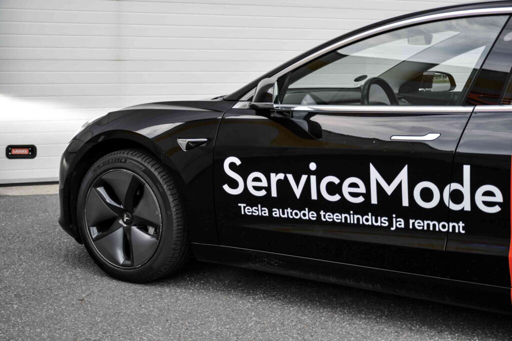 Must Model 3 küljelt, lamedad uksekäepidemed lähivaates